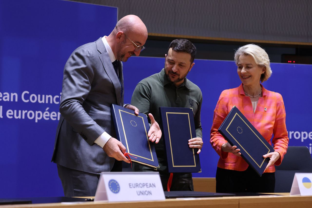 BRUSSELS, BELGIUM - JUNE 27: (----EDITORIAL USE ONLY - MANDATORY CREDIT - 'EUROPEAN COMMISSION / POOL' - NO MARKETING NO ADVERTISING CAMPAIGNS - DISTRIBUTED AS A SERVICE TO CLIENTS----) Ukraine's President Zelensky (C), European Council President Charles Michel and EU Commission President Ursula von der Leye pose with documents as they take part in a signature ceremony of security agreement with the EU during the European Council Summit at the EU headquarters in Brussels on June 27, 2024. (Photo by European Commission / POOL/Anadolu via Getty Images)