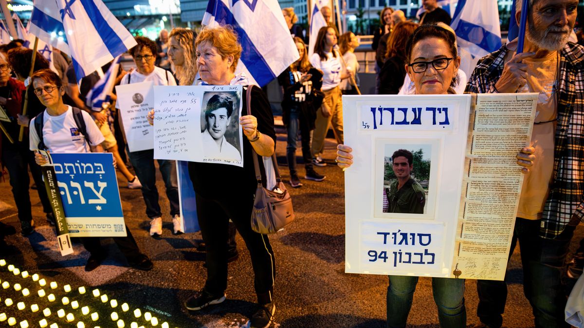 TEL AVIV, ISRAEL - 2023/04/22: Bereaved family members hold placards with photos of their loved ones, next to thousands of "Yom HaZikaron" candles for the Memorial Day of the fallen Israeli soldiers and terror attacks victims during an anti-judicial overhaul demonstration in Tel Aviv. (Photo by Matan Golan/SOPA Images/LightRocket via Getty Images)