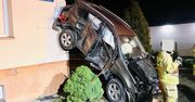 Rozpędzona toyota wypadła z drogi. Auto zawisło na elewacji domu