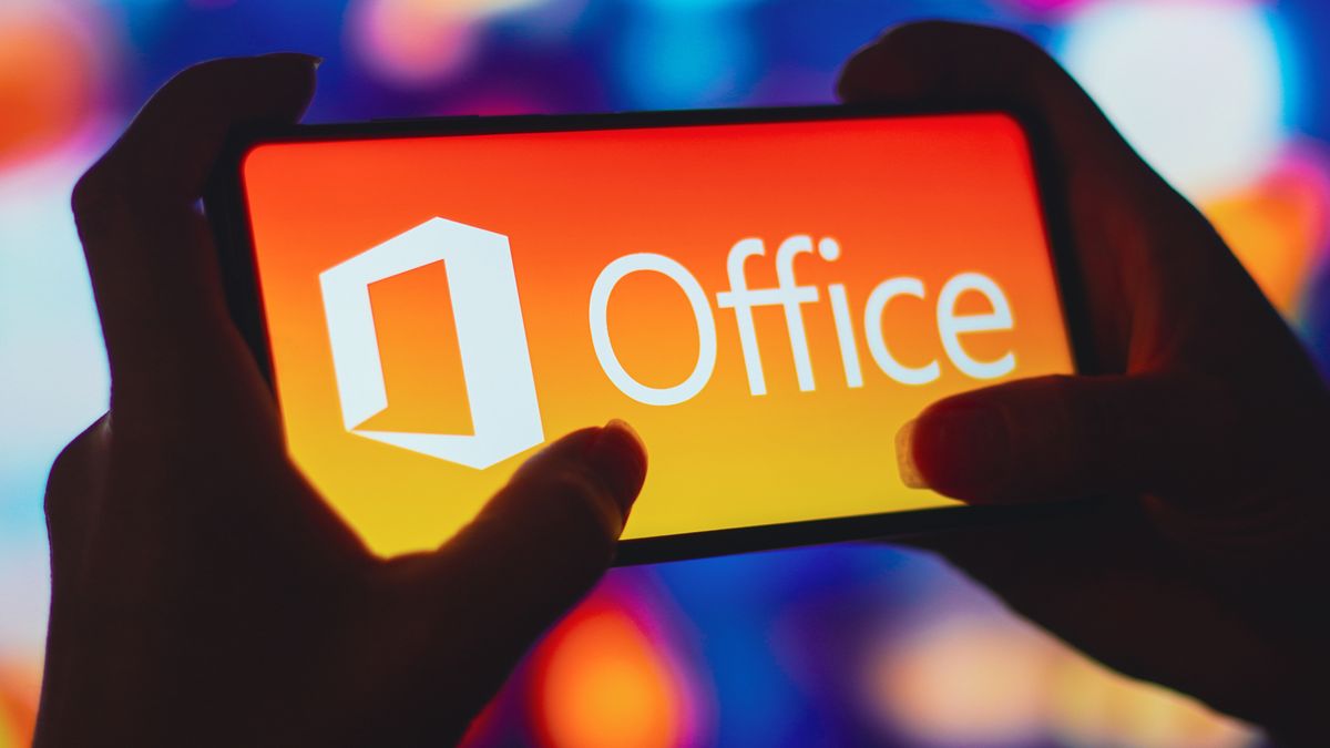 BRAZIL - 2022/07/06: In this photo illustration, a silhouetted woman holds a smartphone with the Microsoft Office logo displayed on the screen. (Photo Illustration by Rafael Henrique/SOPA Images/LightRocket via Getty Images)