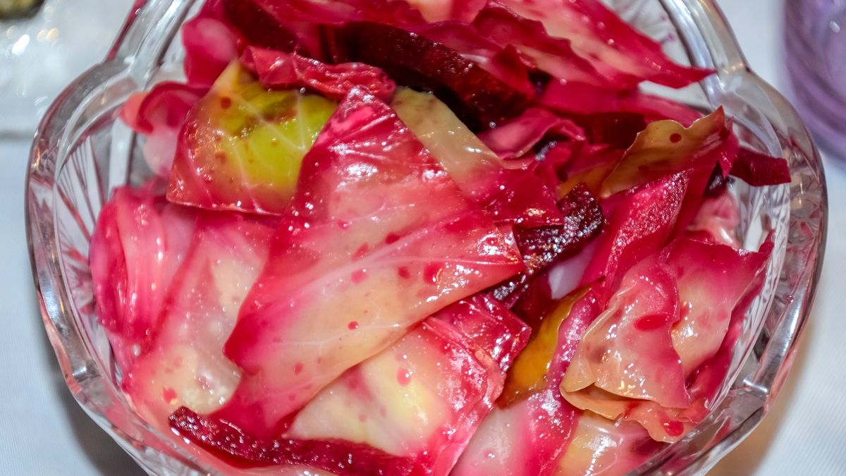 Gruzini kroją kapustę na kawałki i upychają w słoikach.