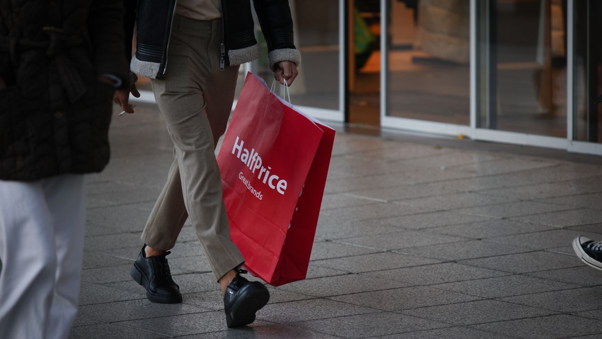 A man holding a HalfPrice brand shopping bag is seen walking in Warsaw, Poland on 03 October, 2022. (Photo by STR/NurPhoto via Getty Images)