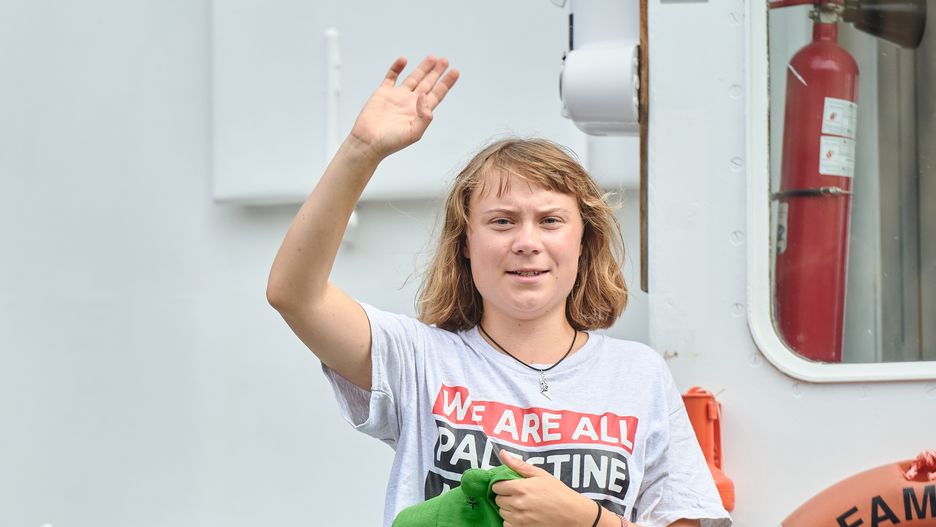 BARCELONA, SPAIN - AUGUST 31: Greta Thunberg waves as she greets people while sailing on the Flotilla boat on August 31, 2025 in Barcelona, Spain. Activists, including Swedish campaigner Greta Thunberg, are departing Barcelona for Gaza as part of the Global Sumud Flotilla (GSF), a self-described "nonviolent humanitarian mission responding to the ongoing genocide and siege against the Palestinian people." The flotilla, which will be joined by others launching from various locations on September 4, includes activists, seafarers, doctors, and artists from over 40 countries. Thunberg and other crew members of a flotilla that attempted to reach Gaza after departing Italy in June were intercepted by Israeli forces and deported back to their countries of origin. (Photo by Mario Wurzburger/Getty Images)