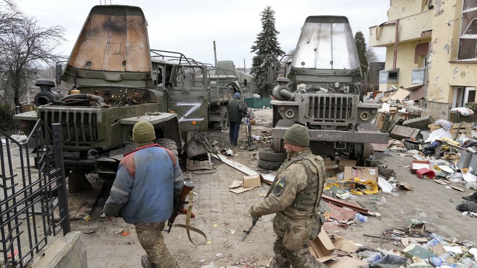 Wojna w Ukrainie - inne miastaUkrainian soldiers pass in front of damaged Russian military trucks in the town of Trostsyanets, some 400km (250 miles) east of capital Kyiv, Ukraine, Monday, March 28, 2022. The more than month-old war has killed thousands and driven more than 10 million Ukrainians from their homes ??" including almost 4 million from their country. (AP Photo/Efrem Lukatsky)AP