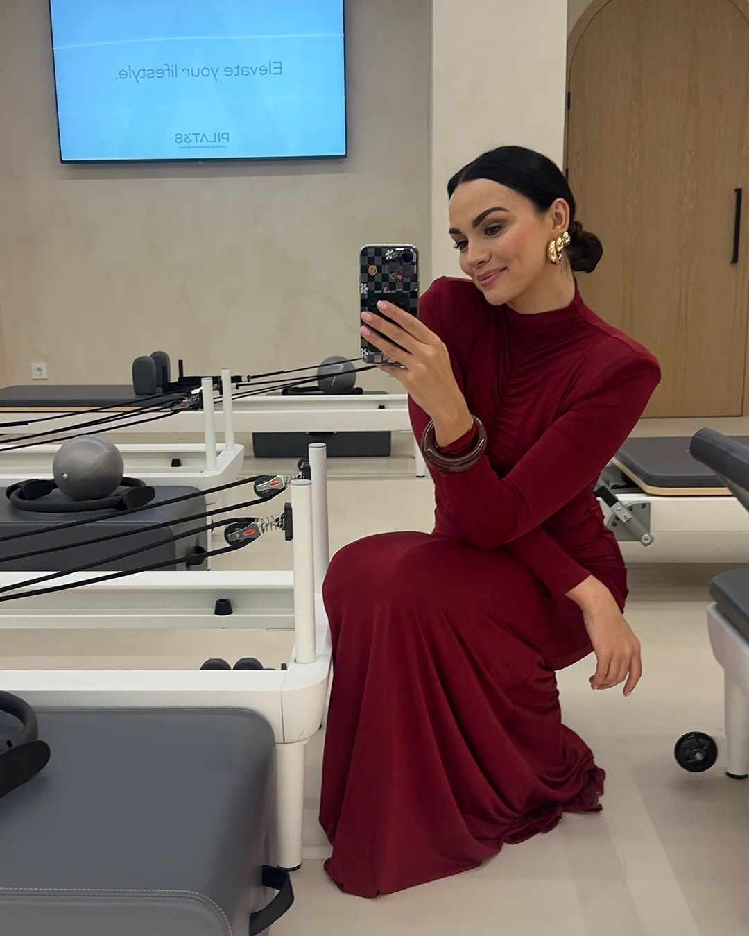 Paulina Krupińska w bordowej sukni na otwarciu studia