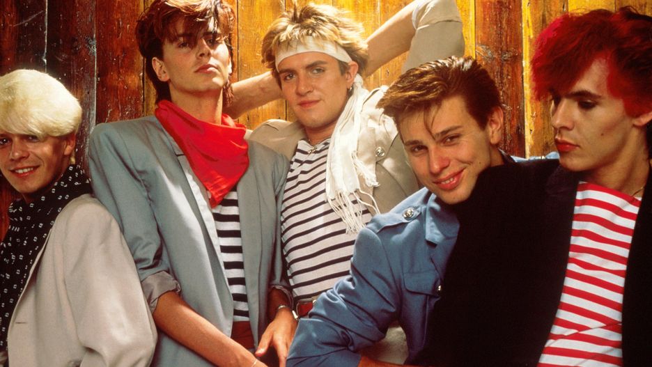 Group Portrait Of Duran Duran
Group Portrait of British band Duran Duran in London, England in 1981. Left to right guitarist Andy Taylor, bassist John Taylor, singer Simon Le Bon, drummer Roger Taylor and keyboard player Nick Rhodes. (Photo by Michael Putland/Getty Images)
Michael Putland
Colour, Eye Contact, Half Length, Headband, Huty 17474, Musician, Posed, Singer, Studio Shot