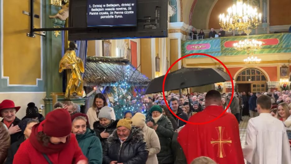 Ksiądz z parasolem podczas mszy