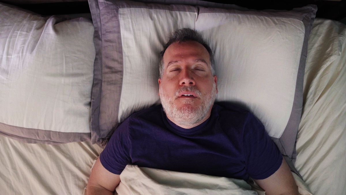 Mature man in bed sleeping on his back snoring with his mouth openMature man in bed sleeping on his back snoring with his mouth openNicolasMcComber
