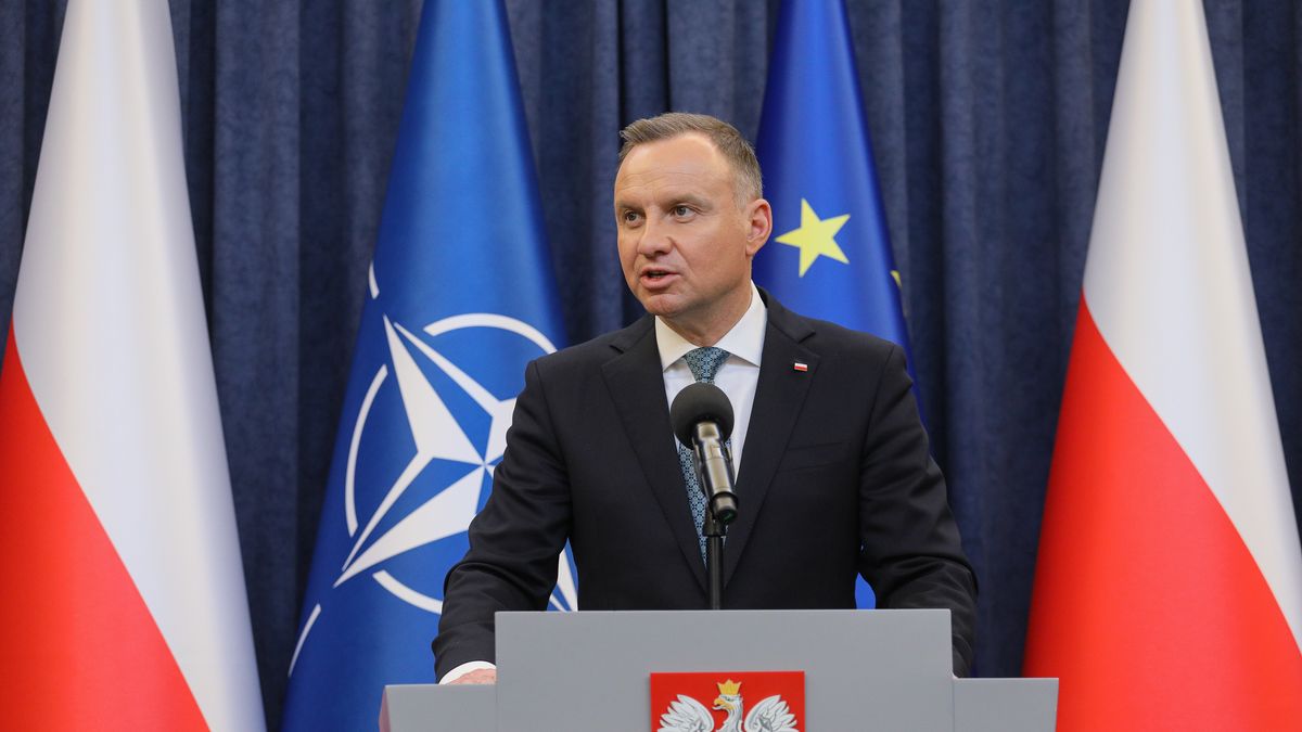 Na zdjeciu Andrzej Duda na tle flag Polski i NATO