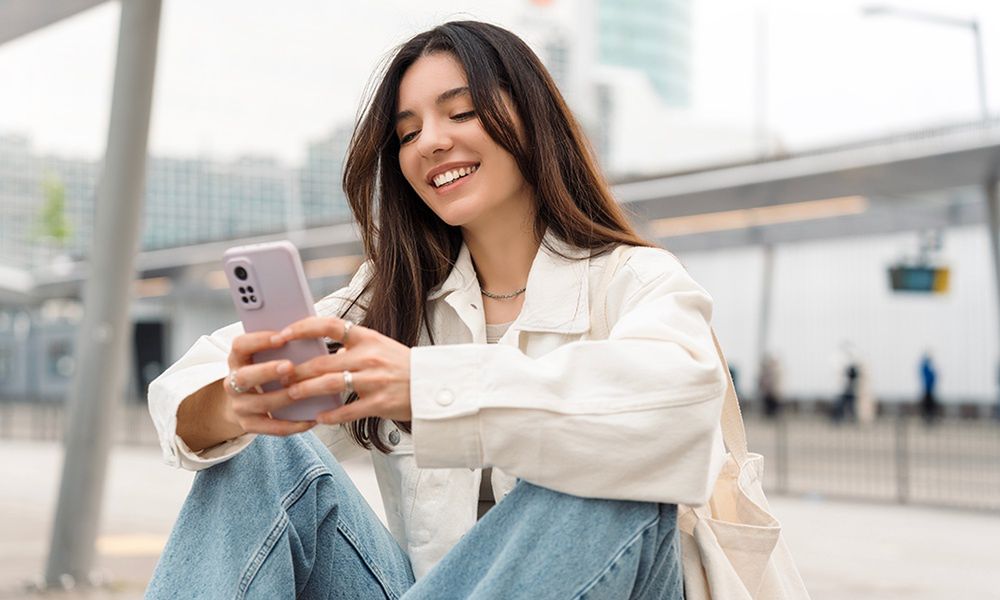  Kobieta uśmiechająca się i trzymająca telefon w dłoniach