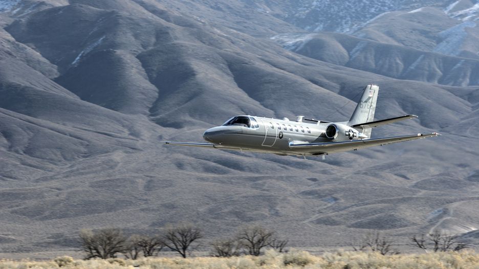 Bishop California, USA, January 26, 2006.  Bishop Airport, (KBIH)  was built in 1928 and expanded and operated by the Army Air Corps during WWII.  During the war it was used as a military flight training base and boasted a chow hall and barracks for pilots during training.  Because of its strategic location east of the 12,000 foot tall Sierra Nevada Mountain range Bishop would be used as a Fall Back Base in the event the Japanese military attacked the California coast.   Today the airport has multiple modern navigational aids and is used by civilian aircraft and all branches of the US military for training and fuel stops.  Bishop has a military fuel contract which allows any military aircraft to purchase fuel.  Because of its close proximity to the Marine Corps High Altitude Training Facility at Pickle Meadows, Bishop is a vital fuel stop.  Aircraft leave their bases on the California coast fully laden with troops and after depositing them at Pickle Meadows stop at Bishop for fuel.   Aircraft perform differently at higher altitudes than at sea level.  Performance is affected by altitude, weight and available power.  Fuel, cargo and passenger loads must be calculated based on altitude, weight and aircraft power.  On a 100 degree day at Bishop's 4,200 foot elevation an aircraft will perform as though it was launching from an airport located 8,000 feet above sea level.  This phenomena is known as Density Altitude.  During workups for deployment to Afghanistan military air units practice in and around the Bishop area because of the high elevation of the airport, sparse population and similarity of terrain.  United States Marine Corps Cessna Citation.  Marine Corps pilots delivering a new Cessna Citation from the factory to Marine Corps Air Station, (MCAS) Miramar, San Diego CA, USA stop at Bishop Airport for fuel and lunch.  After launching from Bishop Airport, pilots perform what is known as a flyby.  Copyright Kenneth Babione