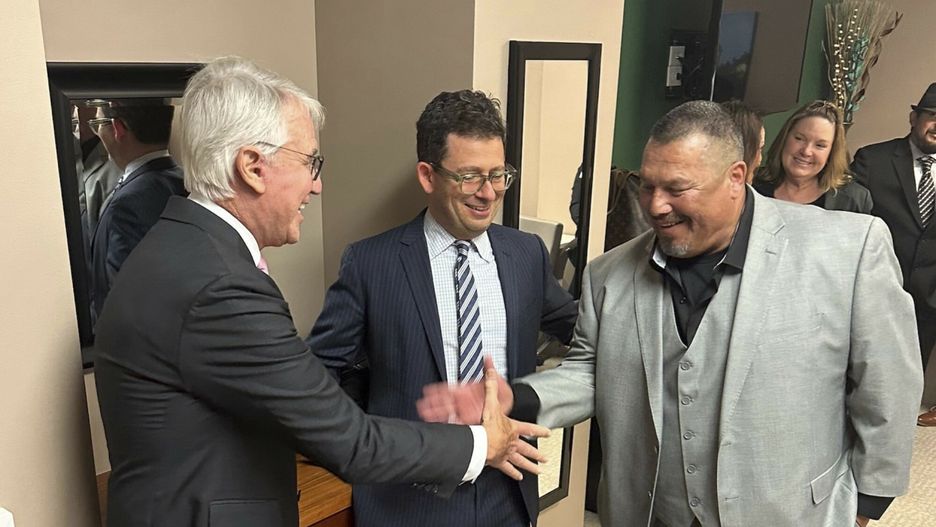 Daniel Saldana, po prawej, ściska dłoń prokuratora okręgowego Los Angeles, George'a Gascona.