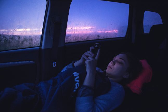 Zachodnie wybrzeże Islandii. Czwórka polskich studentów zwiedza Islandię wypożyczonym autem terenowym, które służy także jako miejsce do spania. Zdjęcie zostało wykonane podczas islandzkiego dnia polarnego, ok. 3 w nocy. Jedna ze studentek kontaktuje się z domem w Polsce za pomocą SMS-ów. 17 czerwca 2017