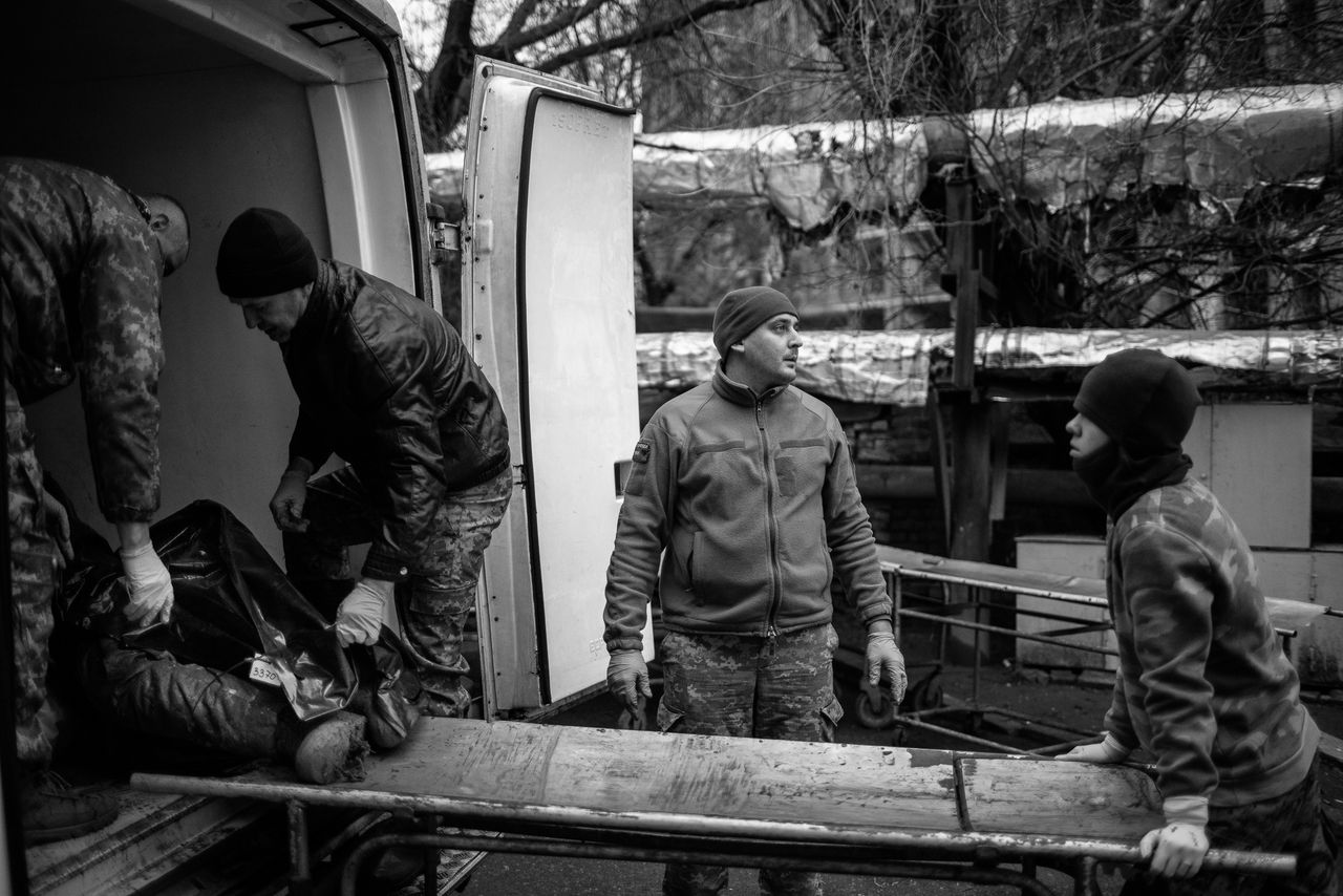Dasza (holding a stretcher) comes to the morgue in Dnipro every day to help unload bodies.