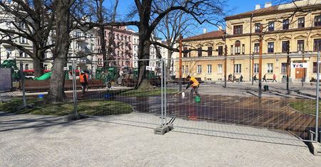 Metalowe ogrodzenie na pl. Litewskim. Zabezpieczają drewniany podest