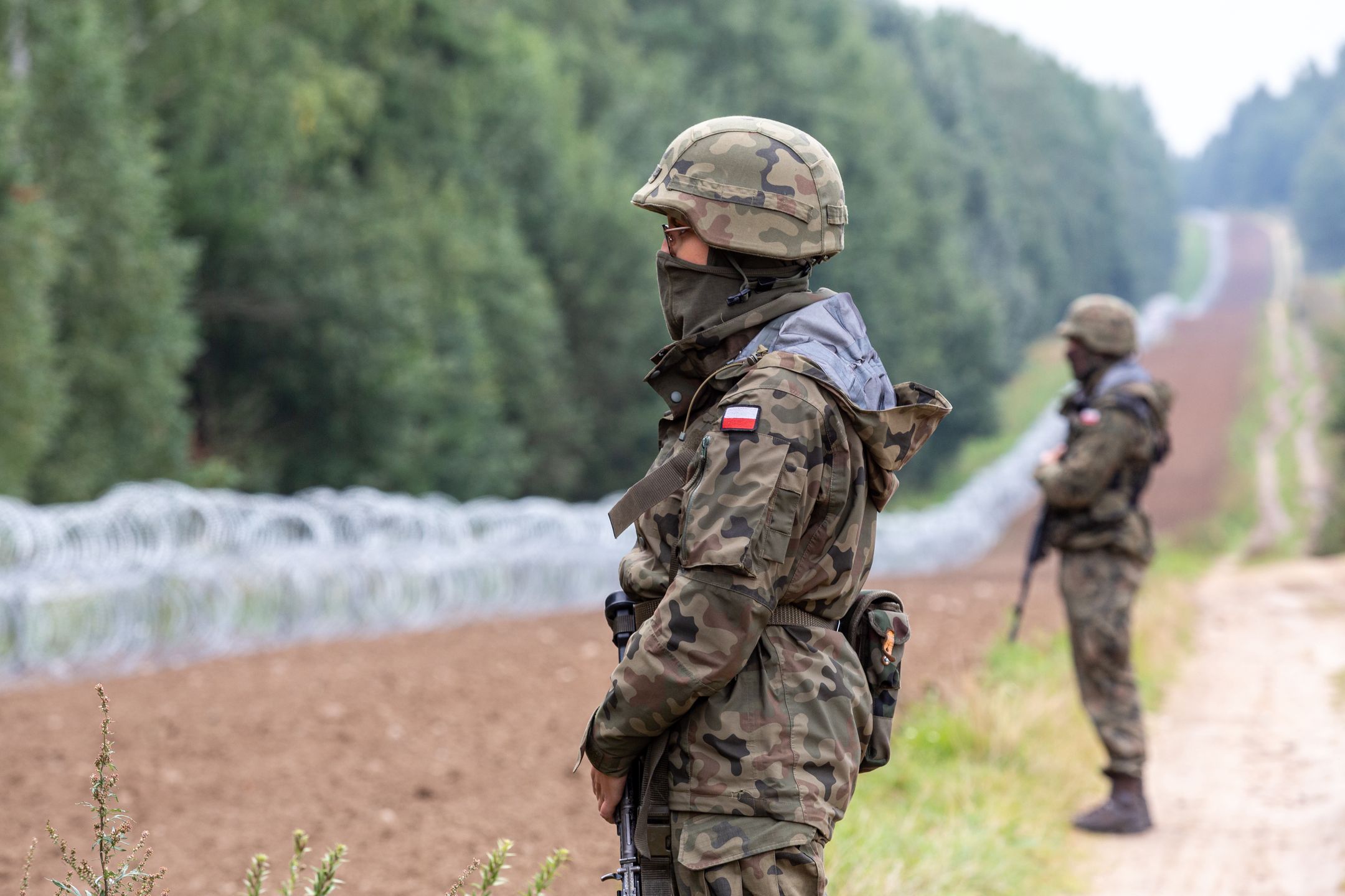 Polish Army Soldiers build a fence with concertina wire at the Belarusian border in order to stop immigrants from entering the country in Krynki, Poland on 27 August, 2021. In August only more than 2000 immigrants entered Poland from Belarus. The Polish government decided to build a fence to put a stop to an influx of migrants walking across the Belarus border. The border between Belarus and Poland is also the border of the European Union. Poland accuses the Lukashenko regime of orchestrating the transit of thousands of migrants from the Middle East to put pressure on the EU. (Photo by Dominika Zarzycka/NurPhoto via Getty Images)