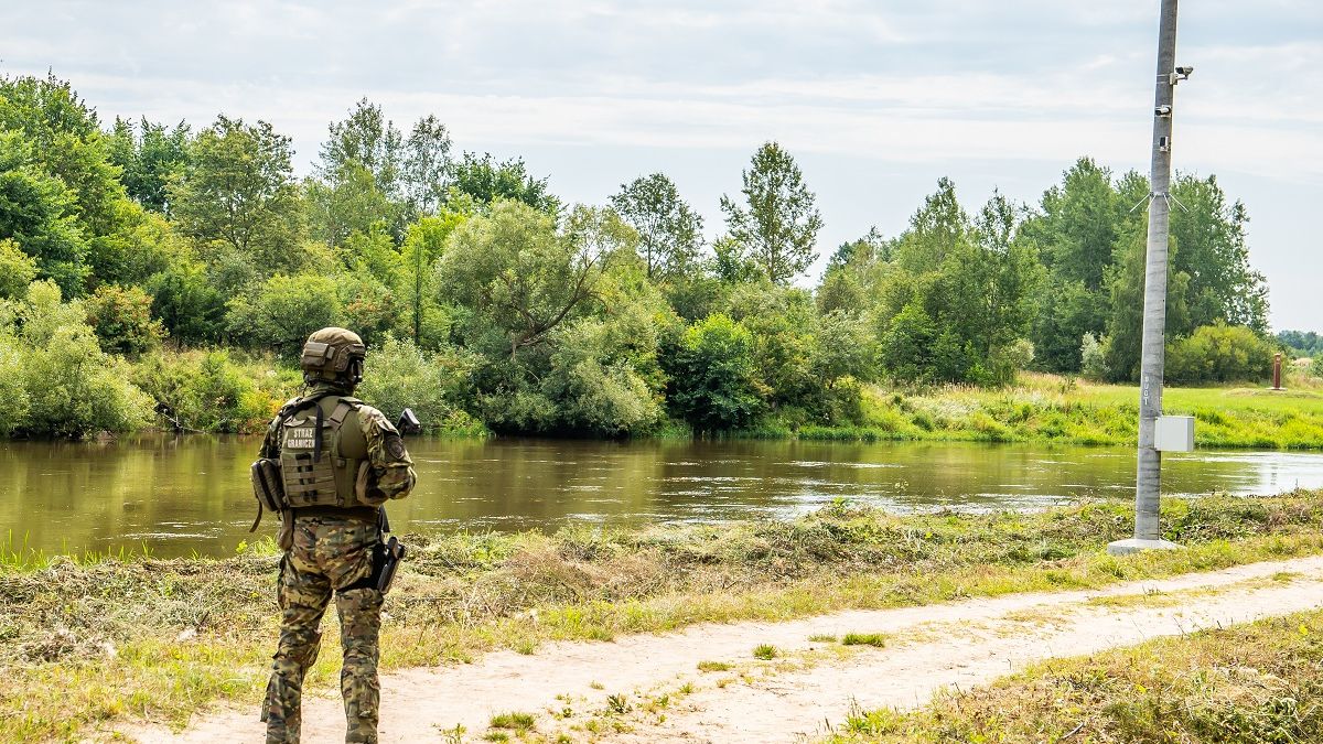Funkcjonariusz SG na tle bariery elektronicznej