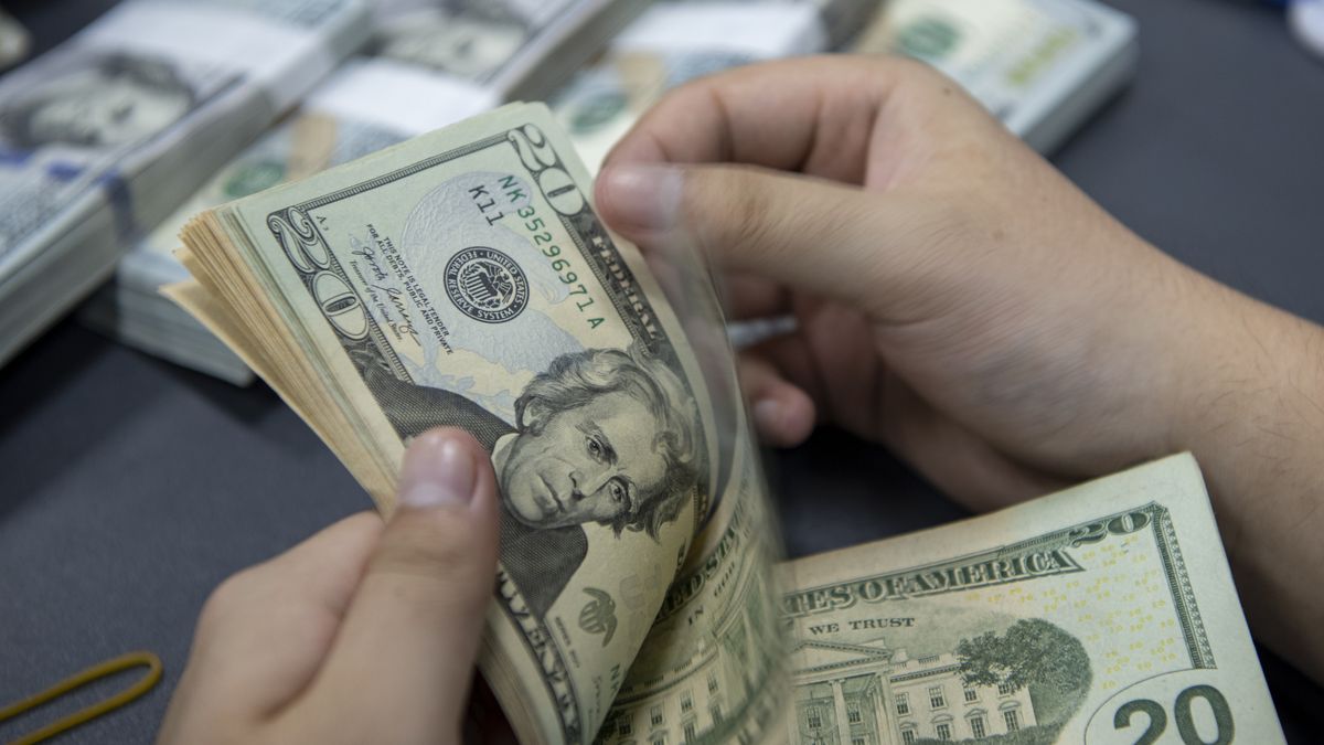 HAI'AN, CHINA - SEPTEMBER 5, 2022 - A staff member counts US dollar cash at a bank in Hai 'an, Jiangsu Province, China, Sept 5, 2022. Effective September 15, 2022, financial institutions will cut the reserve requirement ratio for foreign exchange by 2 percentage points, that is, the reserve requirement ratio will be lowered from the current 8 percent to 6 percent. (Photo credit should read CFOTO/Future Publishing via Getty Images)