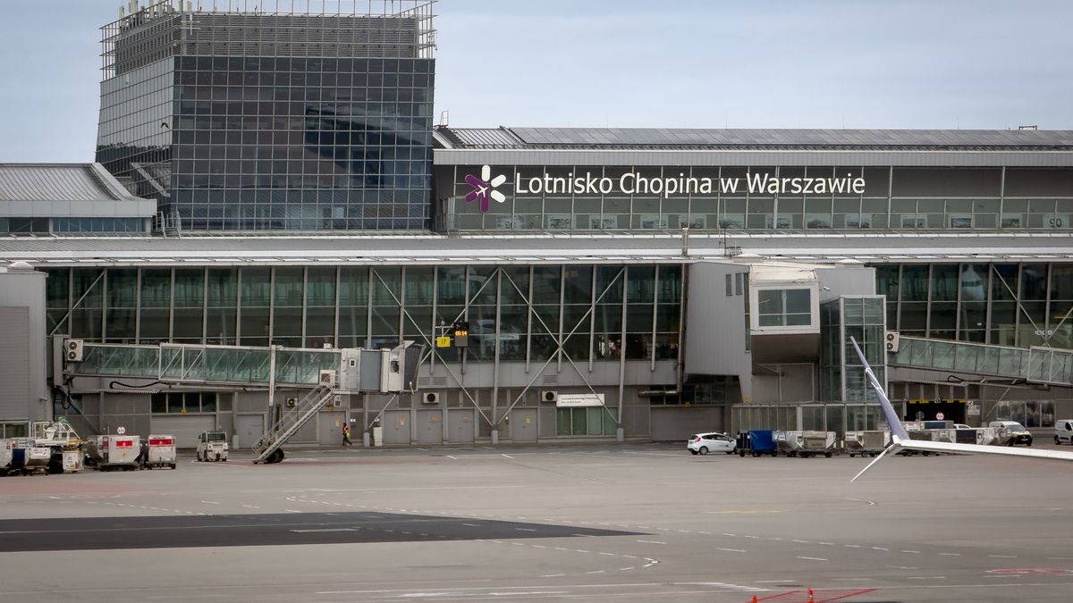 The glass facade of the main passenger terminal at Warsaw Chopin Airport is seen from the apron in Warsaw, Poland, on May 18, 2026. Jet bridges, gates, and a large ''Lotnisko Chopina w Warszawie'' sign are visible on the terminal building. (Photo by Mateusz Wlodarczyk/NurPhoto via Getty Images)