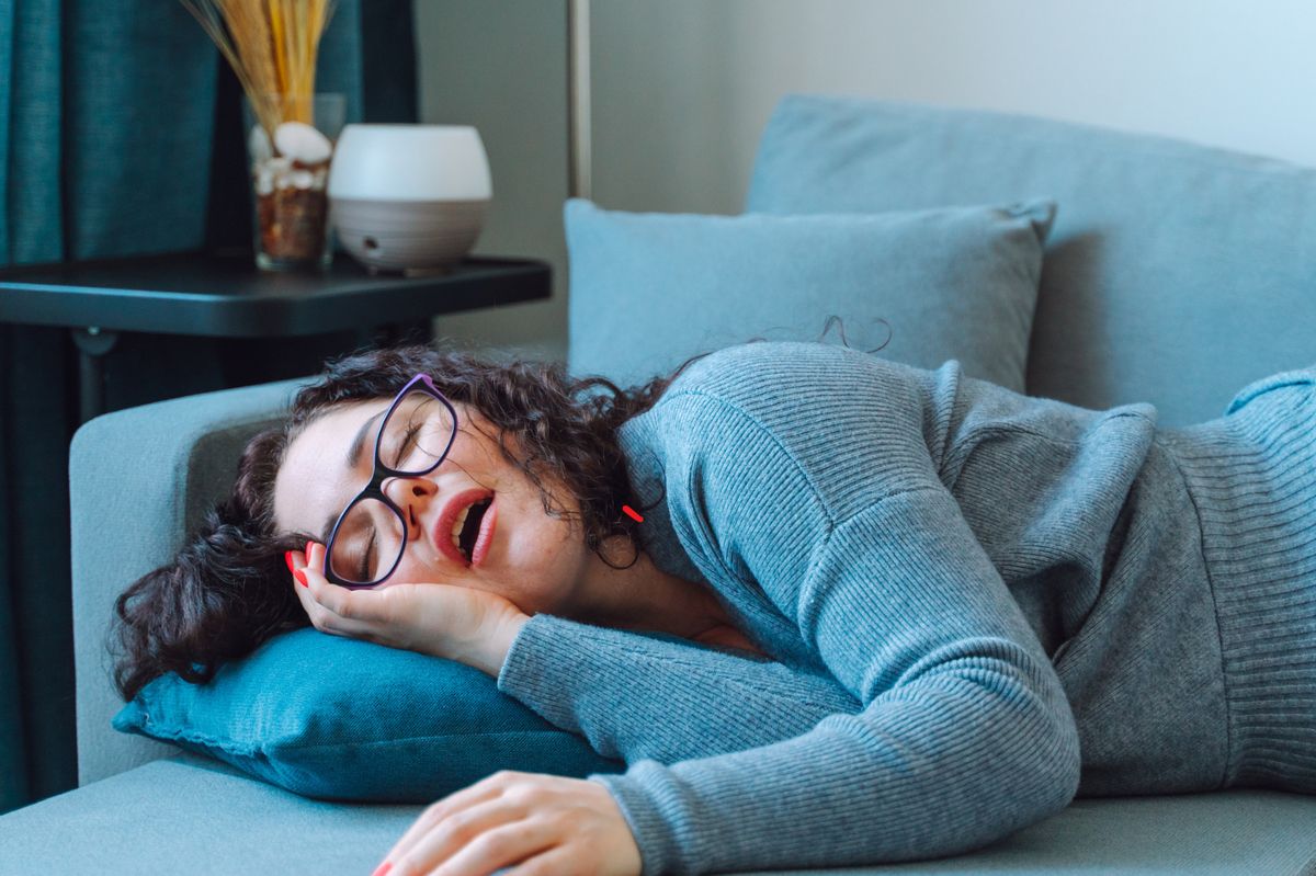 The woman is sleeping on the couch.