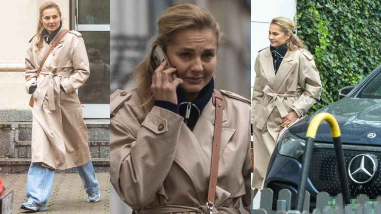 Małgorzata Socha maszeruje po deszczowej Warszawie ze smartfonem przy uchu