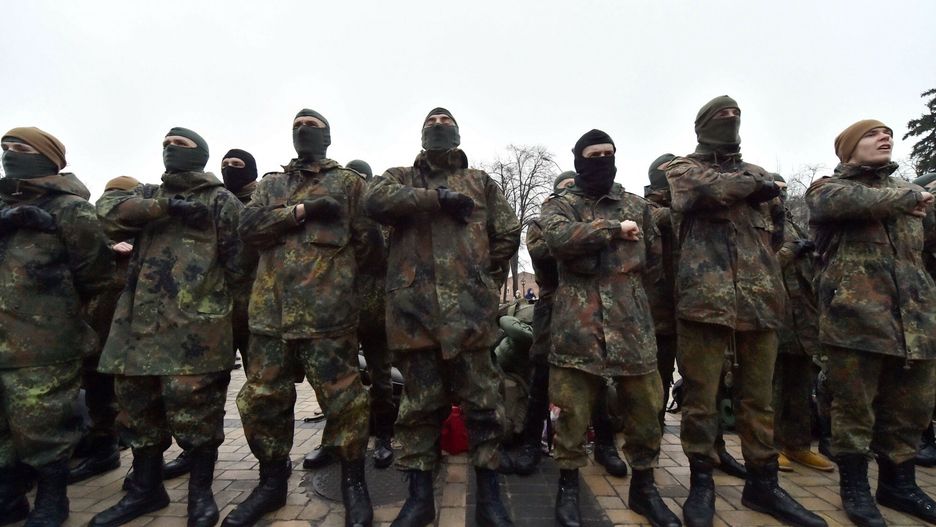 Ochotnicy z batalionu AzowServicemen of Azov, Ukrainian volunteer battalion, hold their fists to their chests as they take an oath during the a ceremony in Kiev on January 17, 2015, before leaving to the east of the country to take part in ATO (anty-terrorists operation). Fighting in eastern Ukraine has killed three soldiers, officials said Saturday, as an upsurge in clashes in recent days between the army and pro-Russian rebels centred around control of a battered airport. AFP PHOTO/ SERGEI SUPINSKYSERGEI SUPINSKY