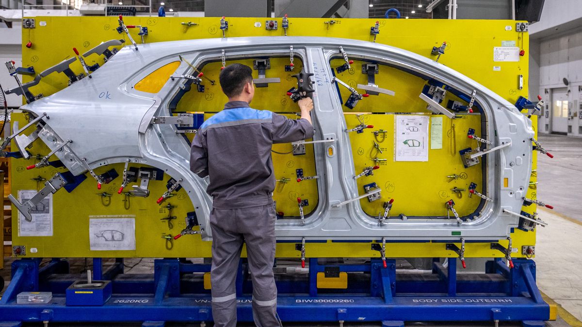 A worker inspects quality of an electric vehicle body side panel at VinFast Auto Ltd.'s manufacturing plant in Hai Phong, Vietnam, on Monday, June 10, 2024. VinFast Auto said it will delay the opening of its electric vehicle factory in North Carolina by three years to 2028. Photographer: Linh Pham/Bloomberg via Getty Images