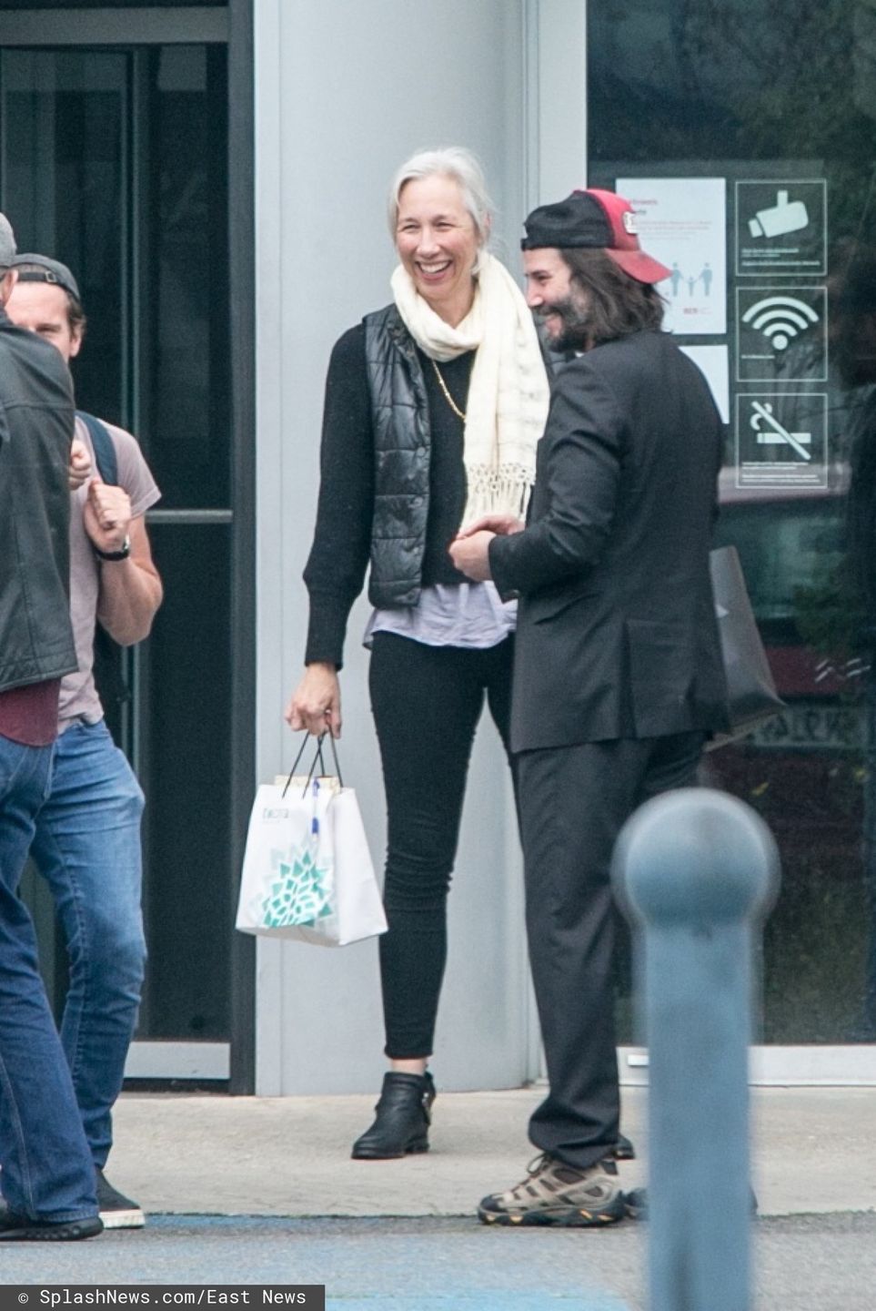 Roześmiani Keanu Reeves i jego dziewczyna na lotnisku