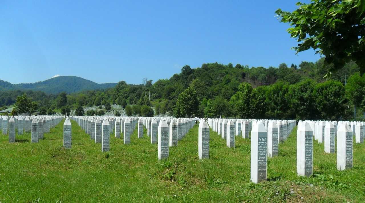 Zielone wzgórza i białe nagrobki to Potočari - miejsce, w którym znajdują się groby ofiar ludobójstwa w Srebrenicy
