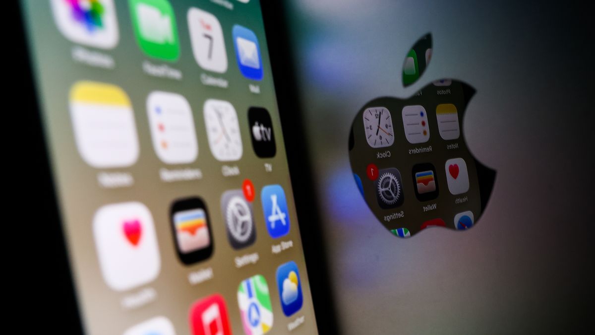 Icons displayed on iPhone screen are seen reflected in Apple logo on MacBook  in this illustration photo taken in Krakow, Poland on October 7, 2025. (Photo by Jakub Porzycki/NurPhoto via Getty Images)