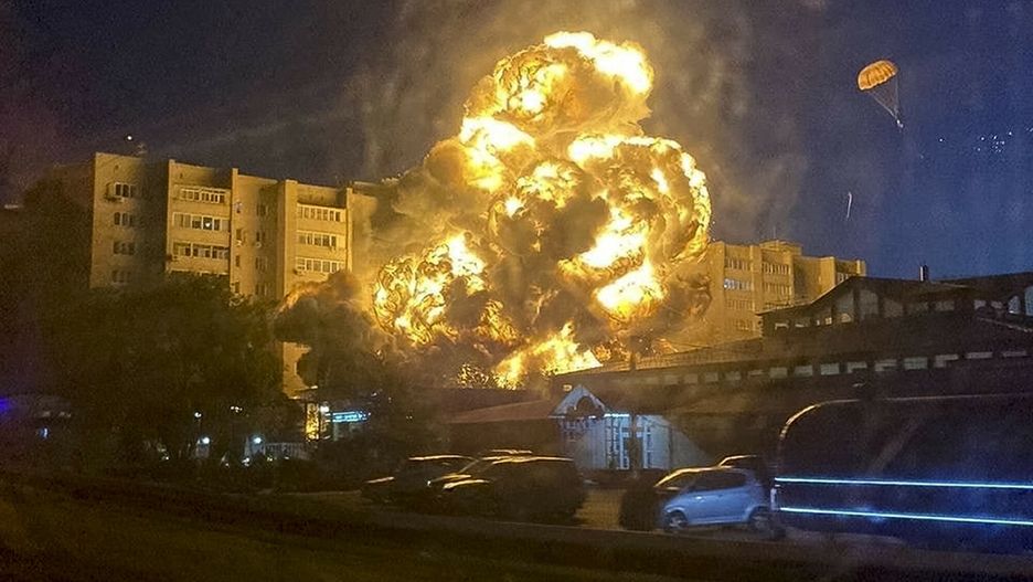 Rosyjski Su-34 rozbi? sie o blok mieszkalny w Jejsku
In this handout photo released by Kooperativ Telegram Channel, flames and smoke rise from the scene after a warplane crashed into a residential area in Yeysk, Russia, Monday, Oct. 17, 2022. The Russian military says one of its warplanes has crashed near an apartment building in Yeysk, a port city on the Sea of Azov, after experiencing engine failure on takeoff. The crash ignited a huge fire, killing at least four people, leaving six missing and injuring 21 others, eight of whom were in grave condition. One of the pilots, right, descends on a parachute. (Kooperativ Telegram Channel via AP)