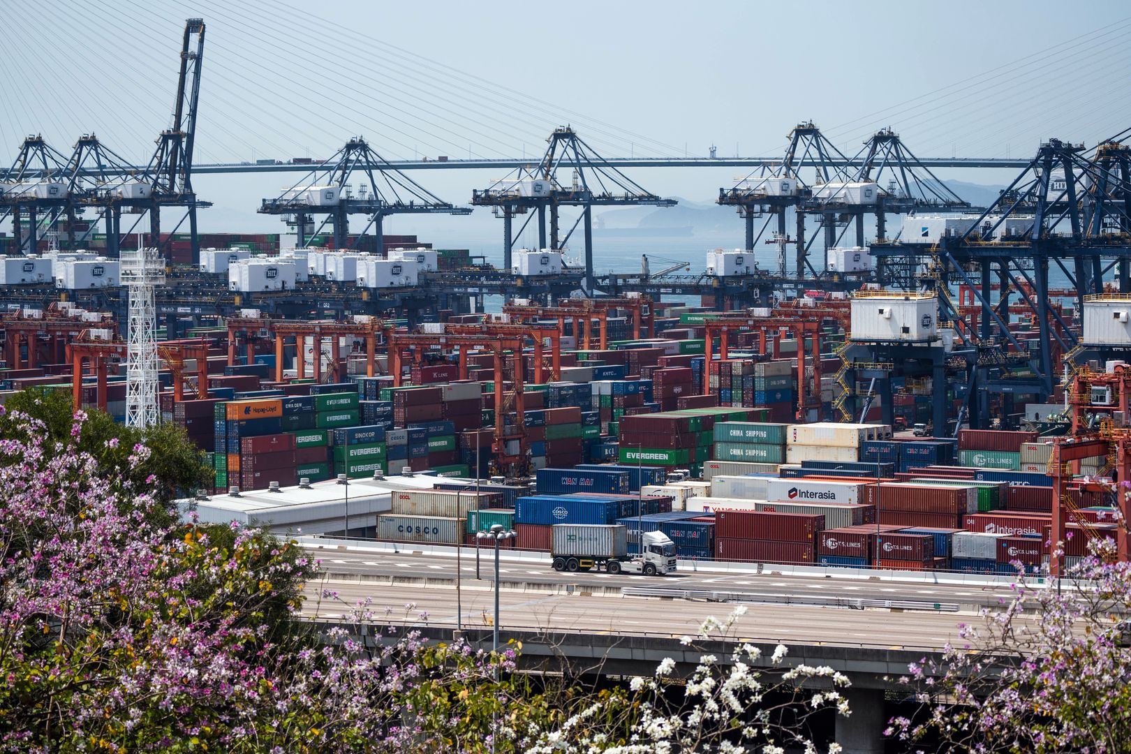 Shipping containers next to gantry cranes operated by Hongkong International Terminals Ltd. at the Kwai Tsing Container Terminals in Hong Kong, China, on Monday, March 14, 2022.  Hong Kong is schedule to release trade figures on March 28. Photographer: Bertha Wang/Bloomberg via Getty Images