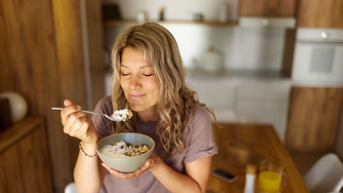 Smiling woman having oatmeal for breakfast at home.
Smiling woman enjoying while eating muesli for breakfast at home.
skynesher