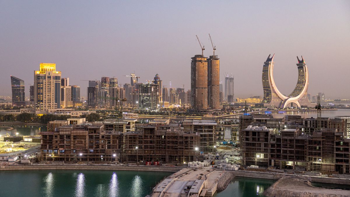 The Katara Towers, right, beyond major construction works in the Lusail development in Doha, Qatar, on Thursday, June 23, 2022. About 1.5 million fans, a little more than half the population of Qatar, are expected to descend upon the tiny Gulf state for this year's FIFA World Cup football tournament. Photographer: Christopher Pike/Bloomberg via Getty Images