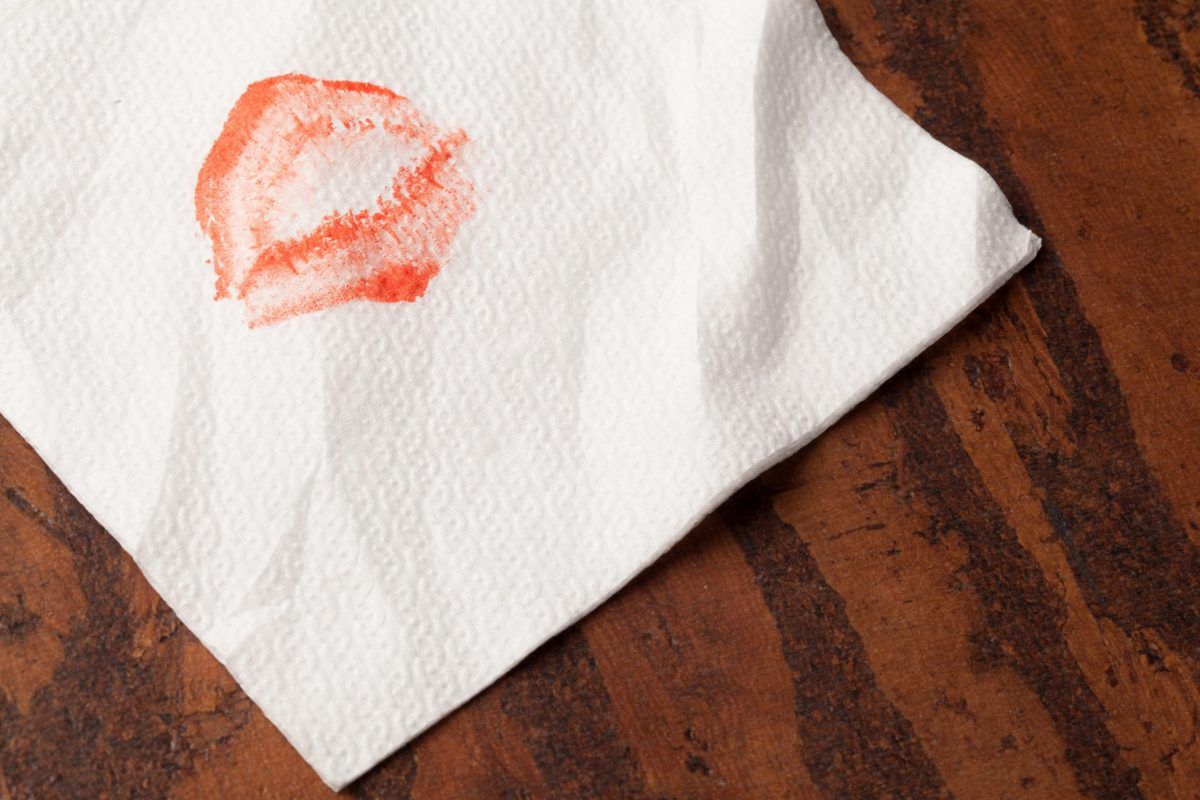 Paper Napkins With Lipstick on wooden background, close-up view