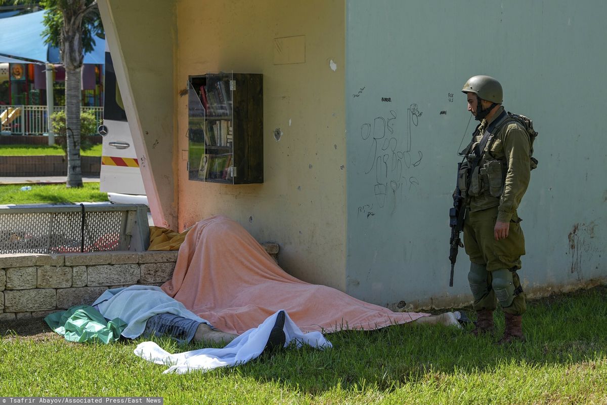 Izraelski żołnierz przy ciałach cywilów zabitych w mieście Sderot