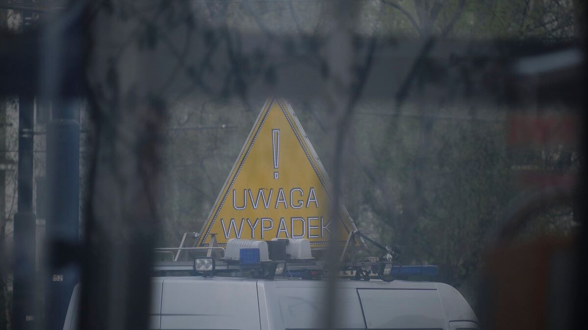 Radiowóz policyjny z tablicą UWAGA WYPADEK