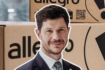 Marcin Kuśmierz na tle przesyłek z Allegro, fot. mat. prasowe