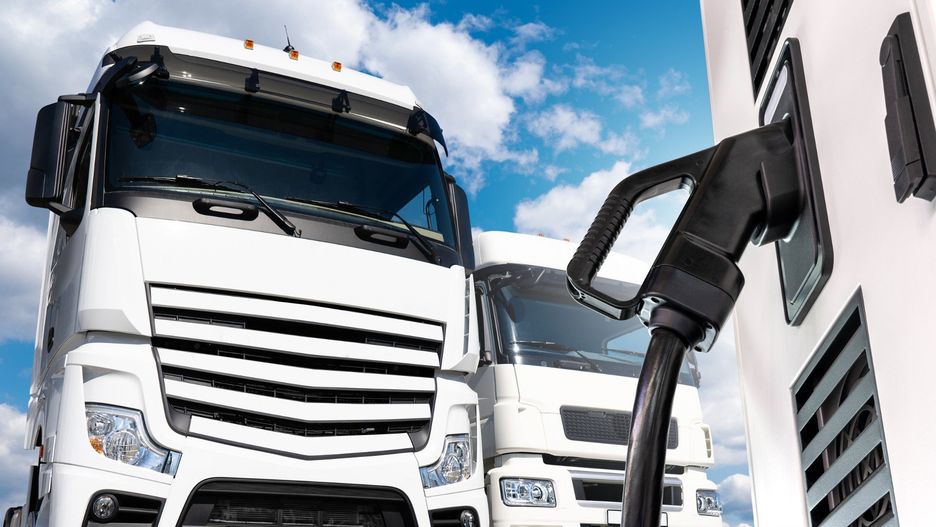 Electric vehicles charging station on a background of a trucks