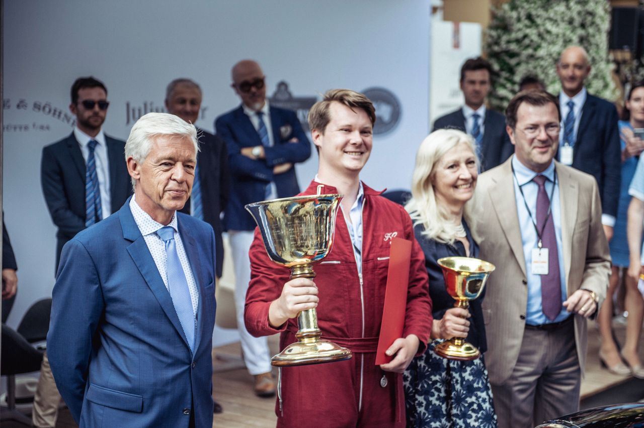 Dzierżący puchar wnuk konstruktora Frederico Goetsche Bebert wraz z Ulrichem Kniepsem, szefem BMW Classic (z lewej) i matką.