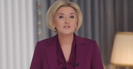 Agata Duda w purpurowej marynarce i koszuli z modną kokardą przemawia podczas oficjalnego wystąpienia. Udana stylizacja? (WIDEO)