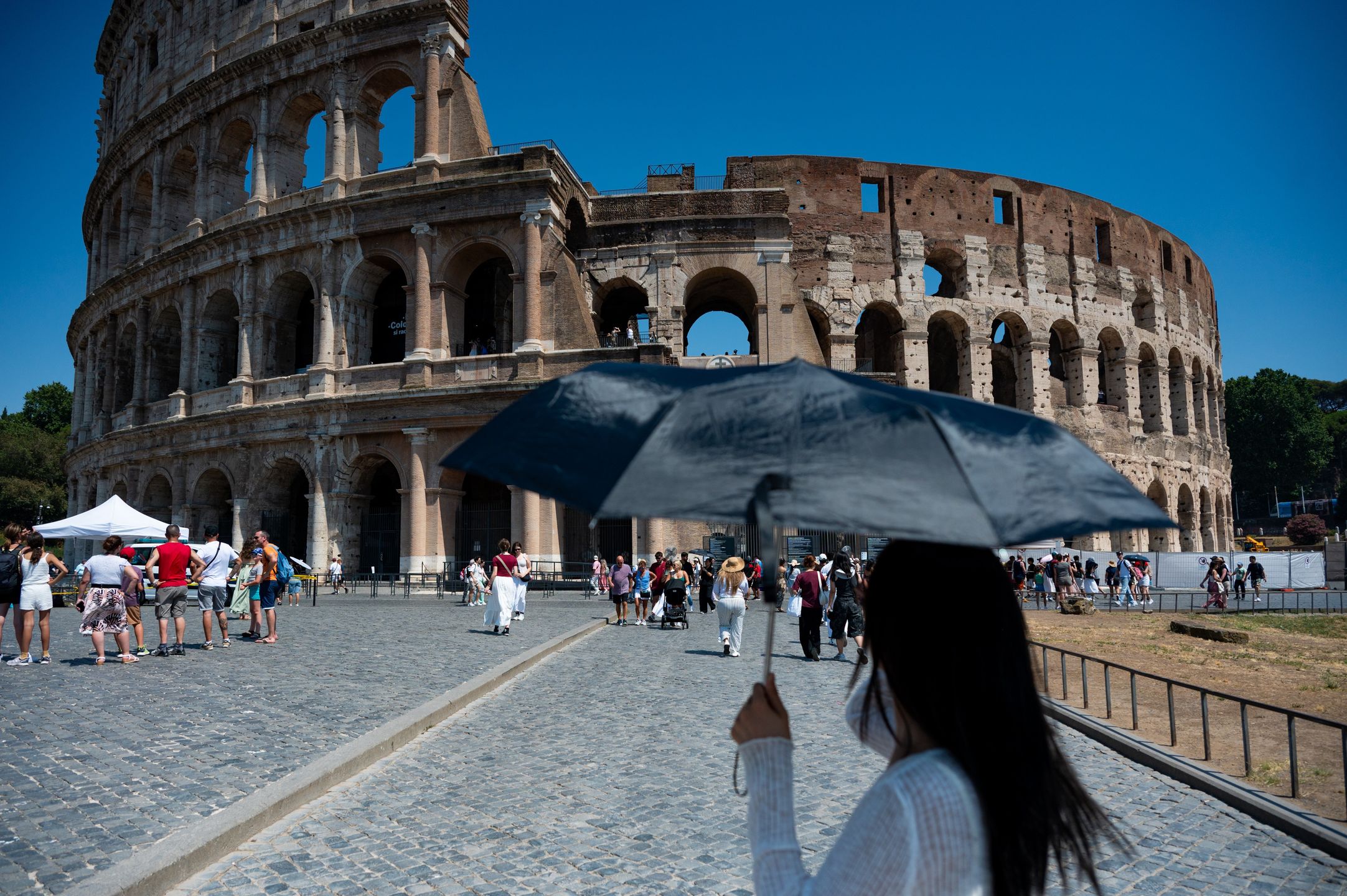 European summers get brutally hot. People hold umbrellas to protect themselves from the sun during an ongoing heat wave with temperatures reaching 40 degrees, in Rome, Italy, on July 6, 2025, at the Colosseo area. (Photo by Massimo Valicchia/NurPhoto via Getty Images)