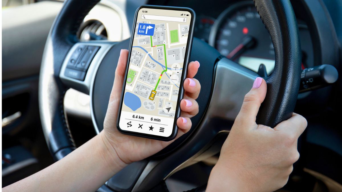 Kobieta w aucie trzyma telefon z nawigacją