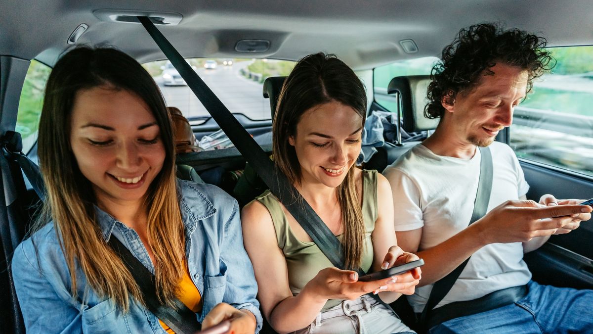 Trzy młode osoby na tylnym siedzeniu samochodu