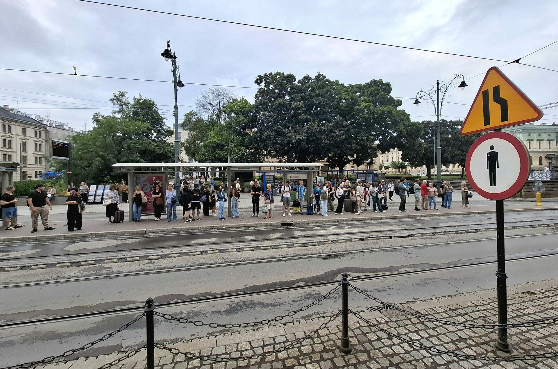 Przystanek tramwajowo-autobusowy &#34;Teatr Słowackiego 01&#34; w Krakowie. Pod jedną wiatą tramwaj i autobus, pod drugą – rozkłady jazdy. Zarząd Transportu Publicznego w Krakowie obiecał przyjrzeć się sytuacji.