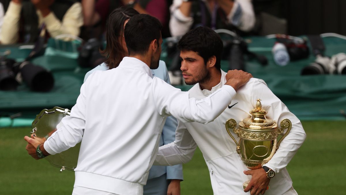 Winner Carlos Alcaraz (R) of Spain and runner-up Novak Djokovic (L) of Serbia hug with their trophies after the Men's Singles final match at the Wimbledon Championships, Wimbledon, Britain, 16 July 2023. EPA/ISABEL INFANTES EDITORIAL USE ONLY Dostawca: PAP/EPA.