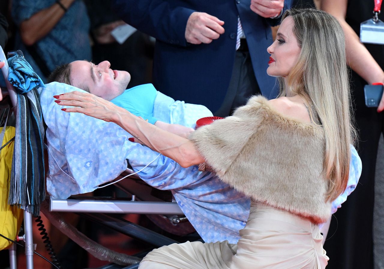 Angelina Jolie speaks with a fan on the red carpet in Venice