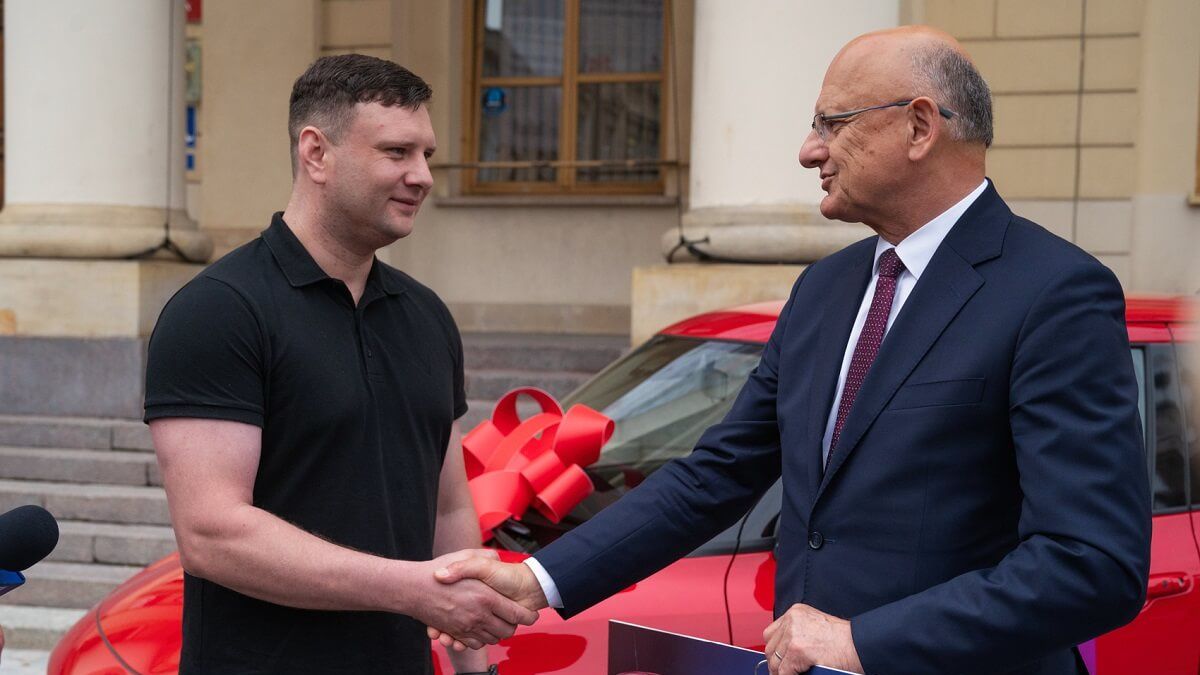 Prezydent miasta Lublin Krzysztof Żuk przekazuje zwycięzcy loterii nagrodę główną