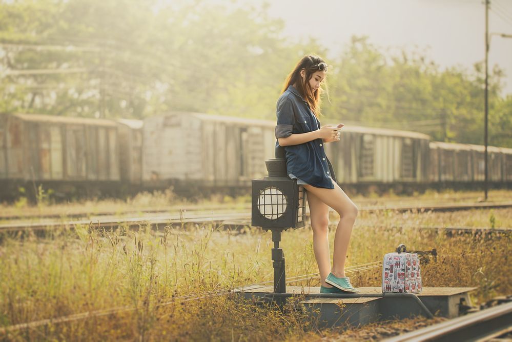 Beautiful girl playing to mobile at railway station