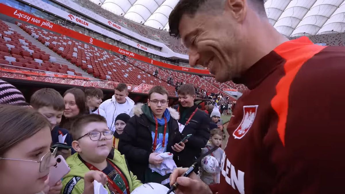 YouTube / @LaczyNasPilka / Na zdjęciu: Robert Lewandowski składa autografy podczas spotkania z dziećmi na PGE Narodowtym